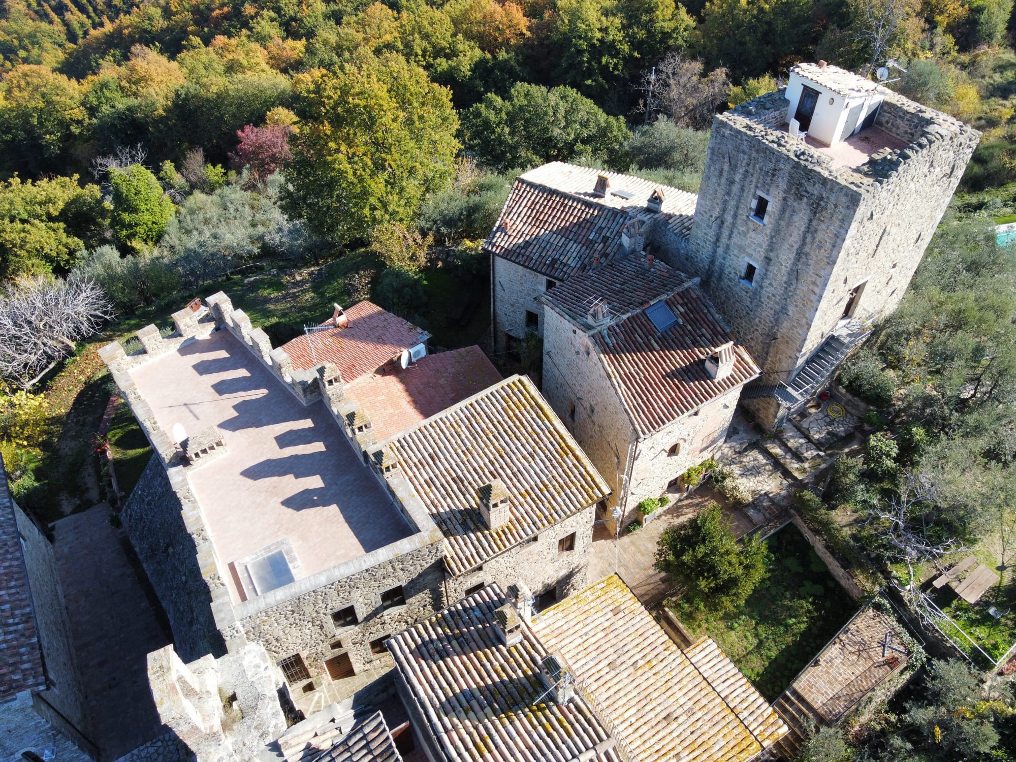 Vista aerea del castello immerso nella campagna, circondato da verdi colline e alberi